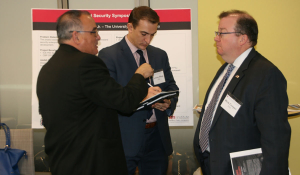 Victor Manjarrez, Jr., associate director for the Center for Law and Human Behavior at the University of Texas at El Paso, explains his educational program, Homeland Security Symposium Series, to visitors of the Borders, Trade, and Immigration Institute's 2017 Showcase Tuesday, December 5, 2017. His display was one twelve projects showcased to an audience of Department of Homeland Security personnel, non-profit think tanks, and academic institutions.